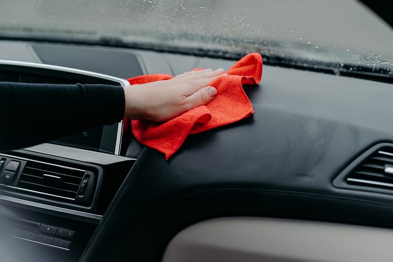 Professional cleaner and car cleaning concept. Unrecognizable man cleans car interior with cloth