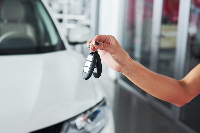 Passing car keys. Cropped closeup of a car dealer holding out car keys to the camera copyspace car