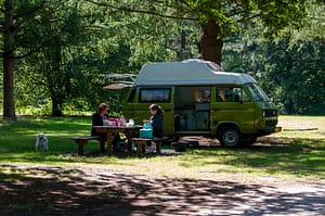 Twee dames zijn aan het picknicken met hun camperbusje.
