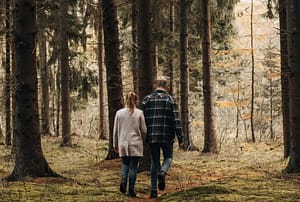 twee personen wandelen in het bos.