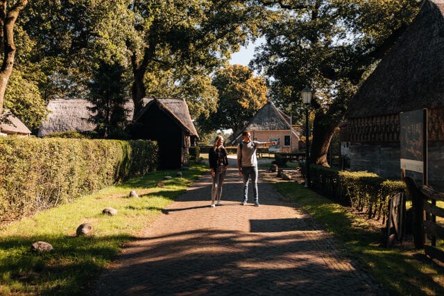 Twee personen lopen in een Brink dorp.
