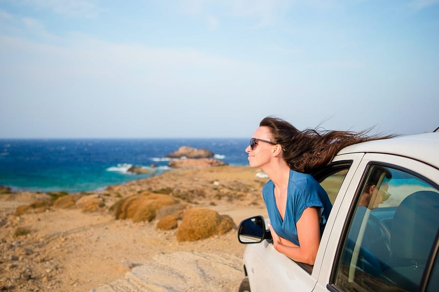 Happy woman on vacation travel by car. Summer holiday and car travel concept